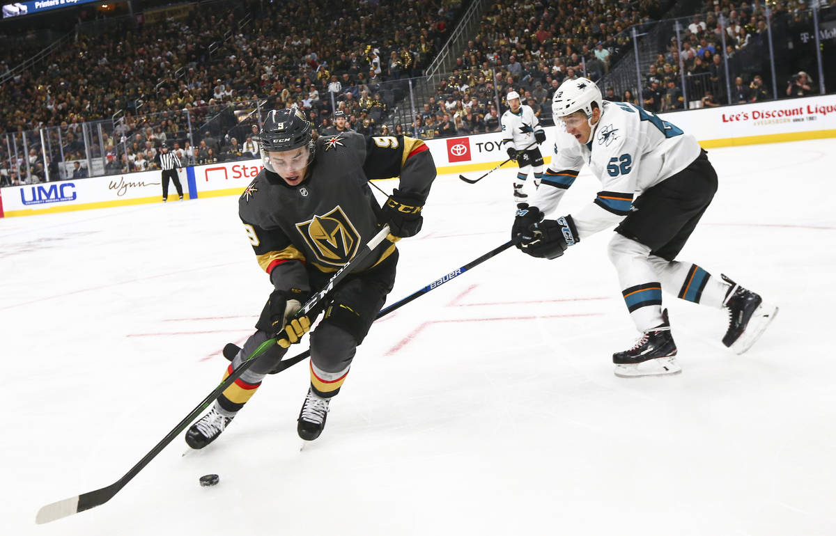 Golden Knights' Cody Glass (9) skates with the puck around San Jose Sharks' Lukas Radil (52) du ...