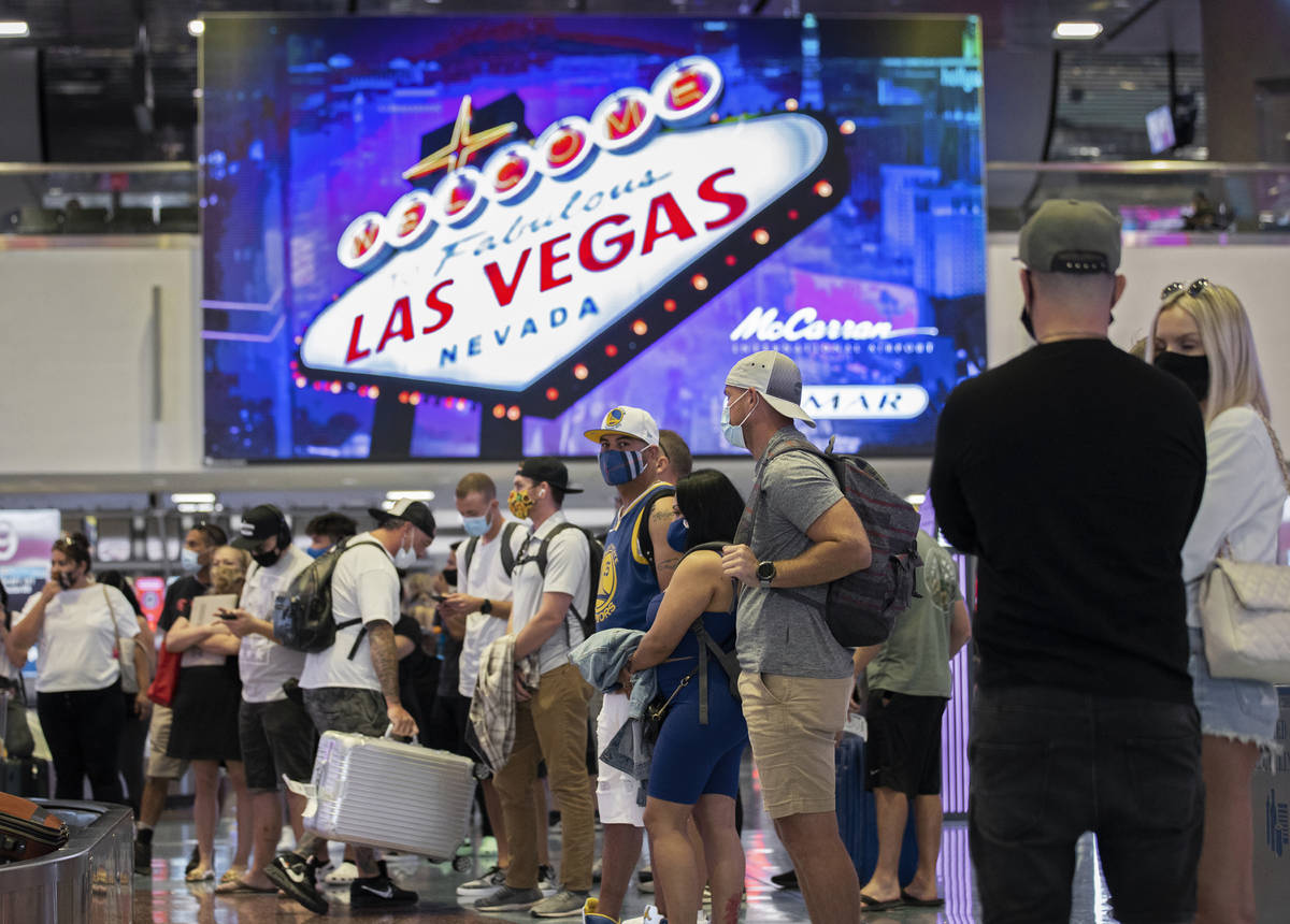 Arriving passengers wait for their luggage in the terminal 1 baggage claim area at McCarran Int ...