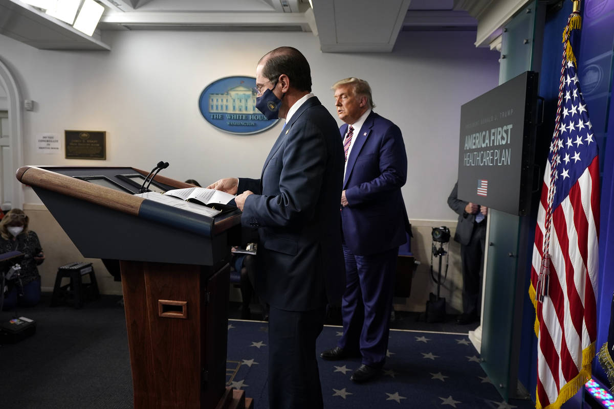 President Donald Trump listens as Health and Human Services Secretary Alex Azar prepares to spe ...