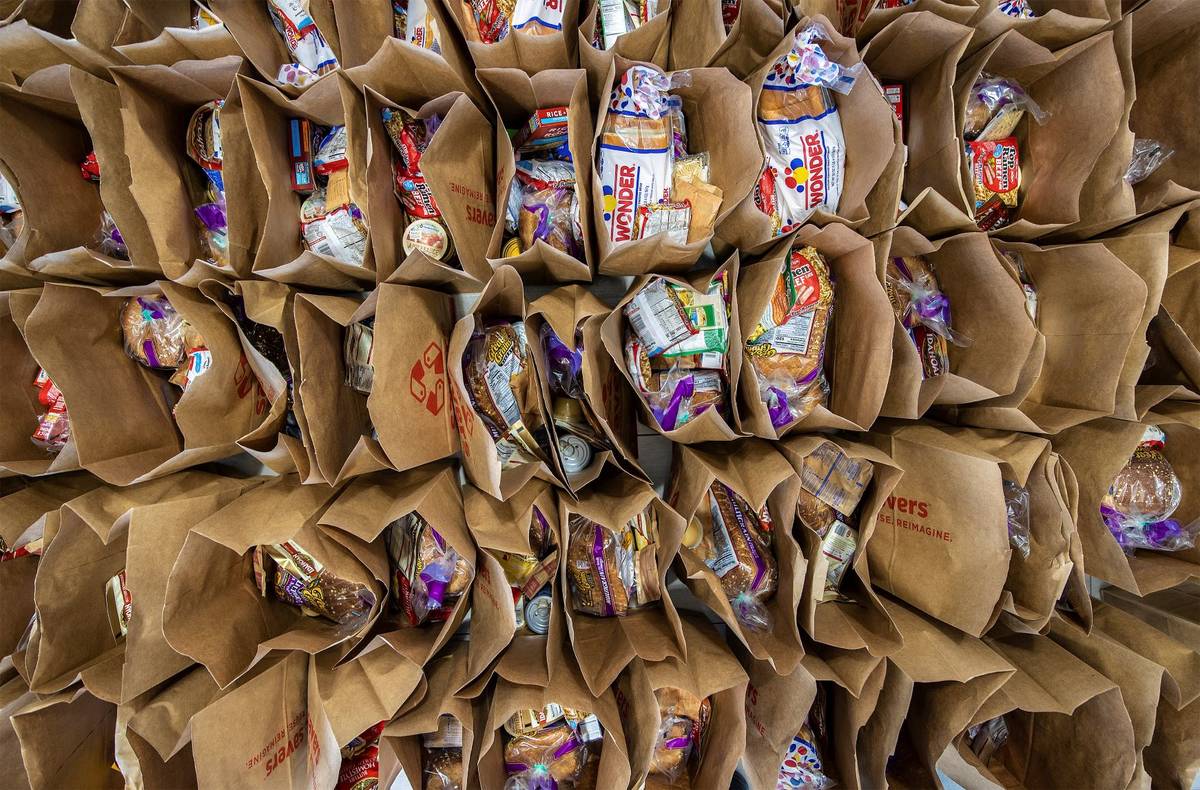 Bags of donated food wait to be handed out during a food drive hosted by Nectar Bath Treats on ...
