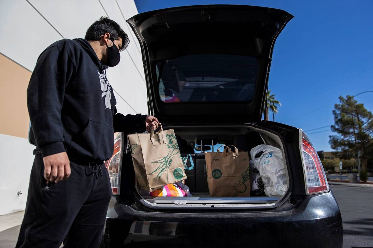 Tristan Sanchez delivers bags of donated food to a vehicle during a food drive hosted by Nectar ...
