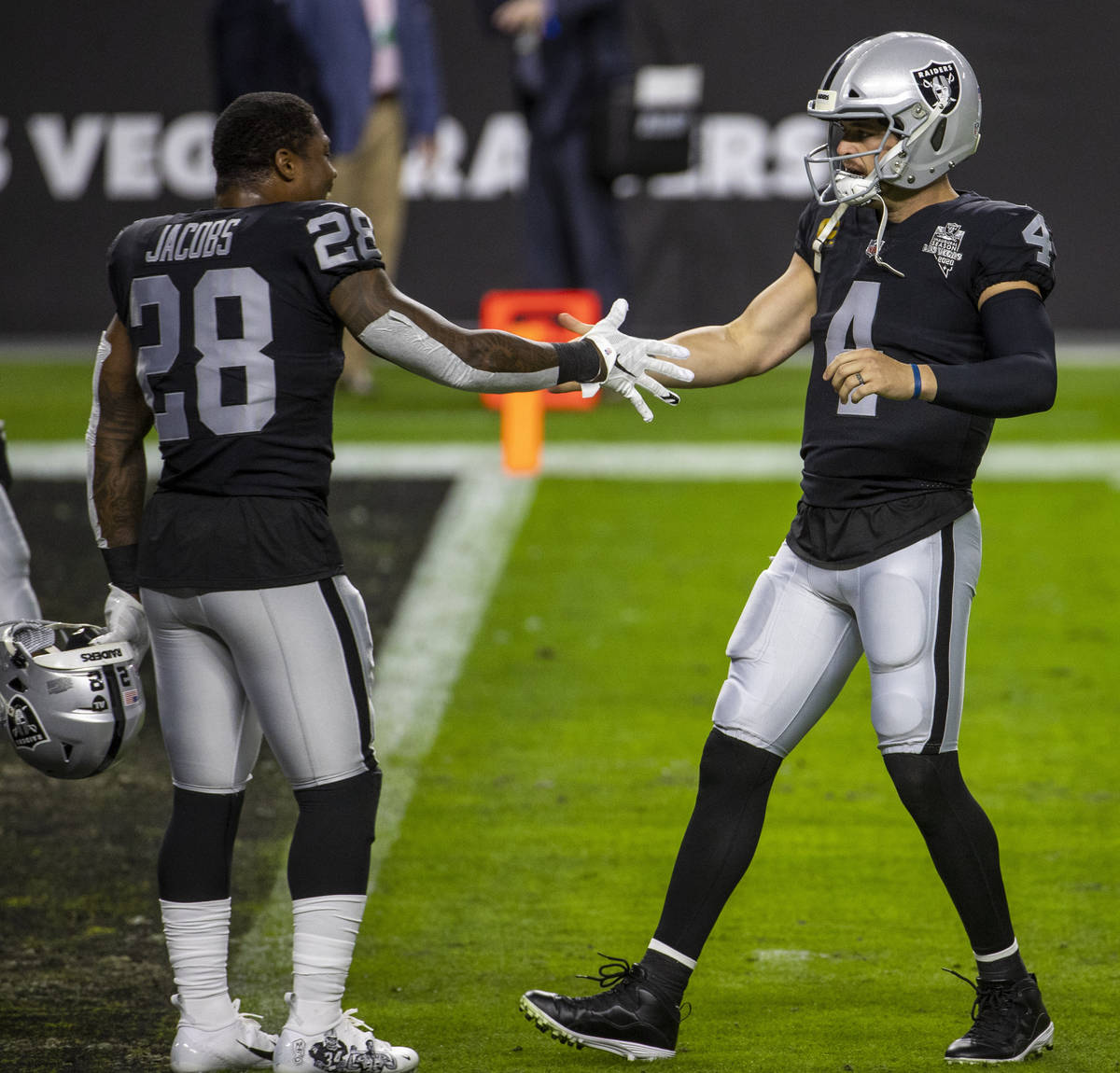 Las Vegas Raiders running back Josh Jacobs (28, left) greets quarterback Derek Carr (4) during ...