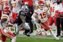 Kansas City Chiefs quarterback Patrick Mahomes (15) scrambles past Las Vegas Raiders defensive ...