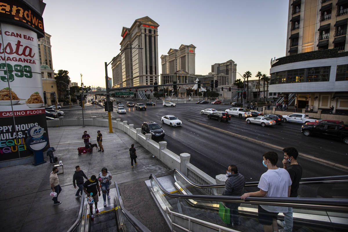 People take an escalator to a pedestrian bridge over Flamingo Road at the Las Vegas Strip Thurs ...