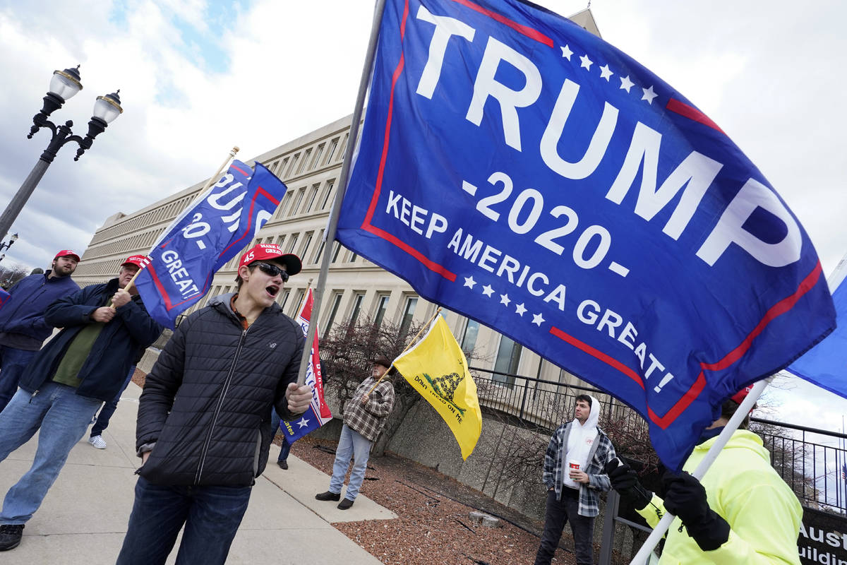 Max Versluys stands outside the Richard H. Austin state office building during a rally in Lansi ...