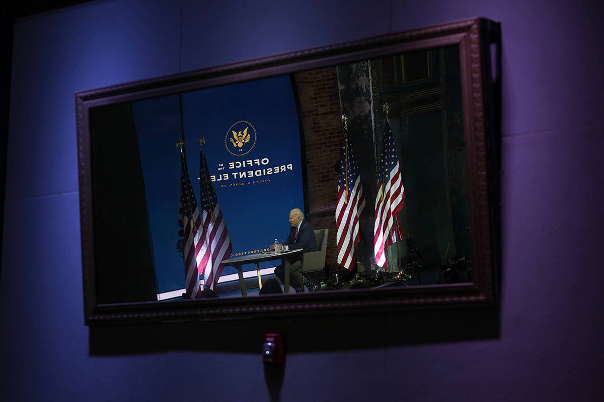 President-elect Joe Biden is reflected in a mirror as he meets virtually with the United States ...