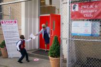 In this Sept. 9, 2020, file photo, a student wears a protective masks as they arrive for classe ...