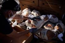 A volunteer unpacks frozen turkeys to give away at a free Thanksgiving food distribution event ...