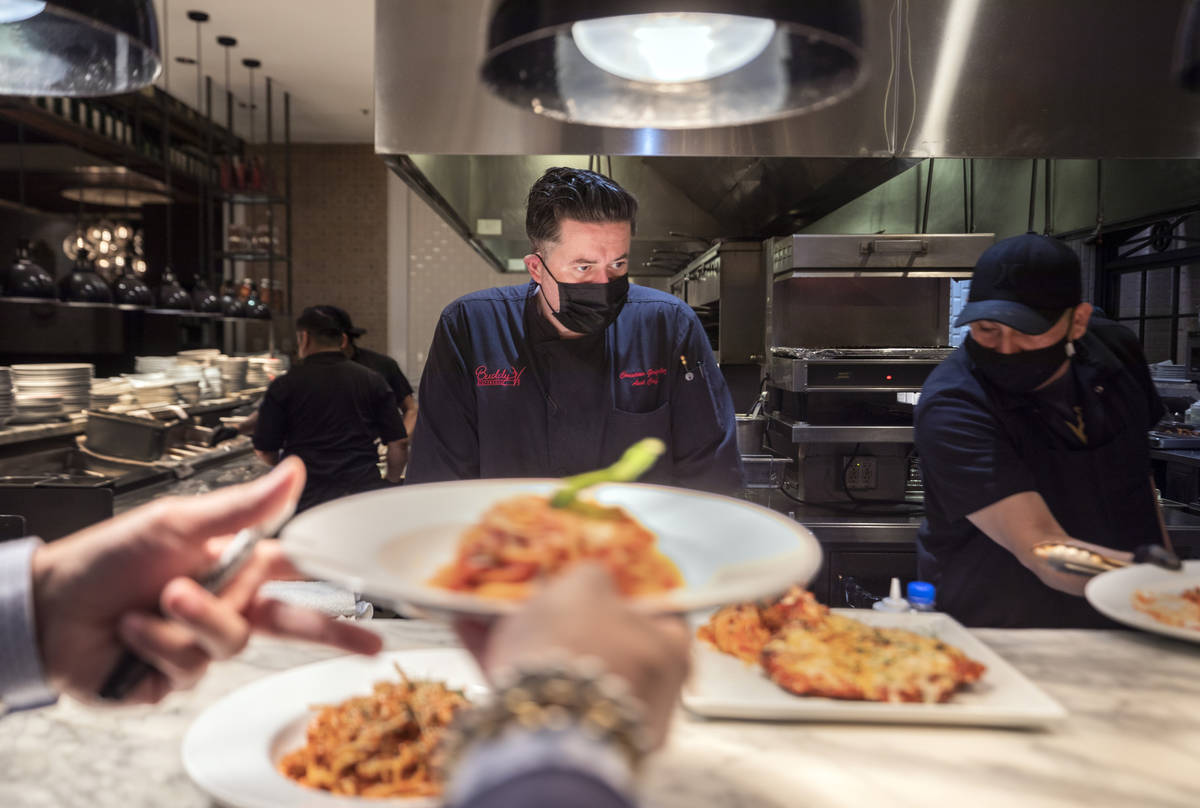 Executive sous chef Christian Gonzalez-Borda, center, oversees dishes going out to be served at ...
