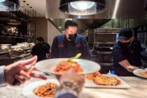 Executive sous chef Christian Gonzalez, center, oversees dishes going out to be served at Buddy ...