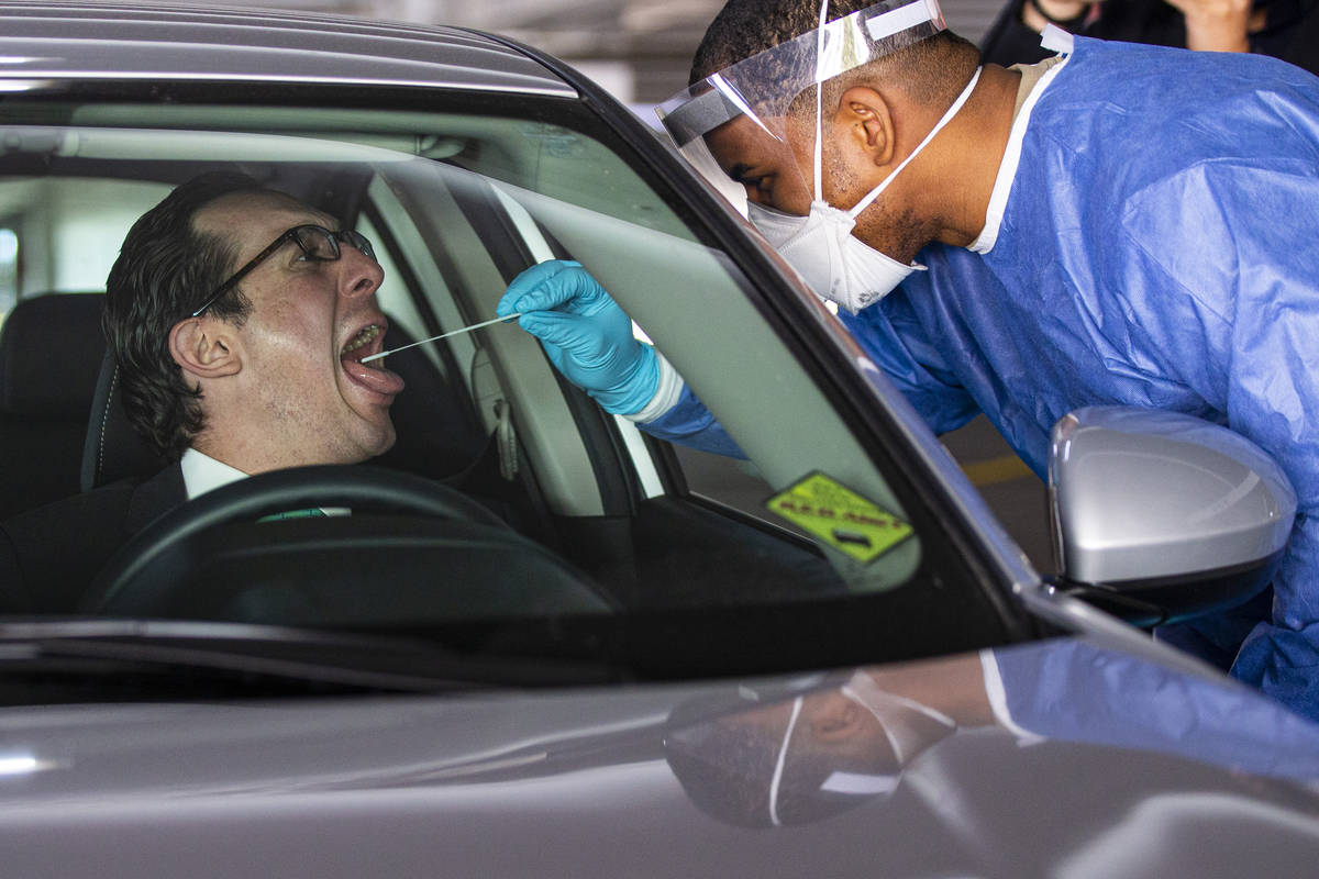 Julian Escutia Rodriguez, the consul of Mexico in Las Vegas, left, gets a swab test from Nevada ...