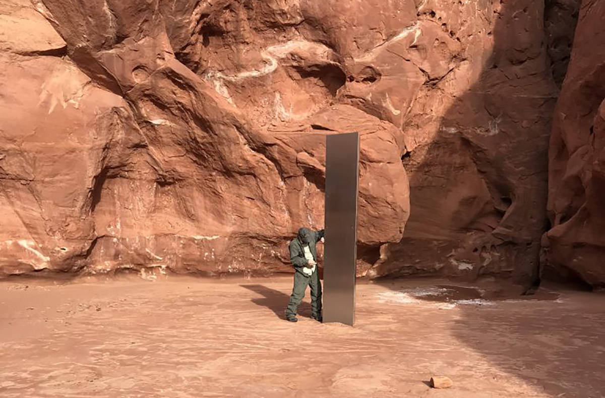 A crew member next to a metal monolith discovered Nov. 18, 2020, in a remote southeast Utah can ...