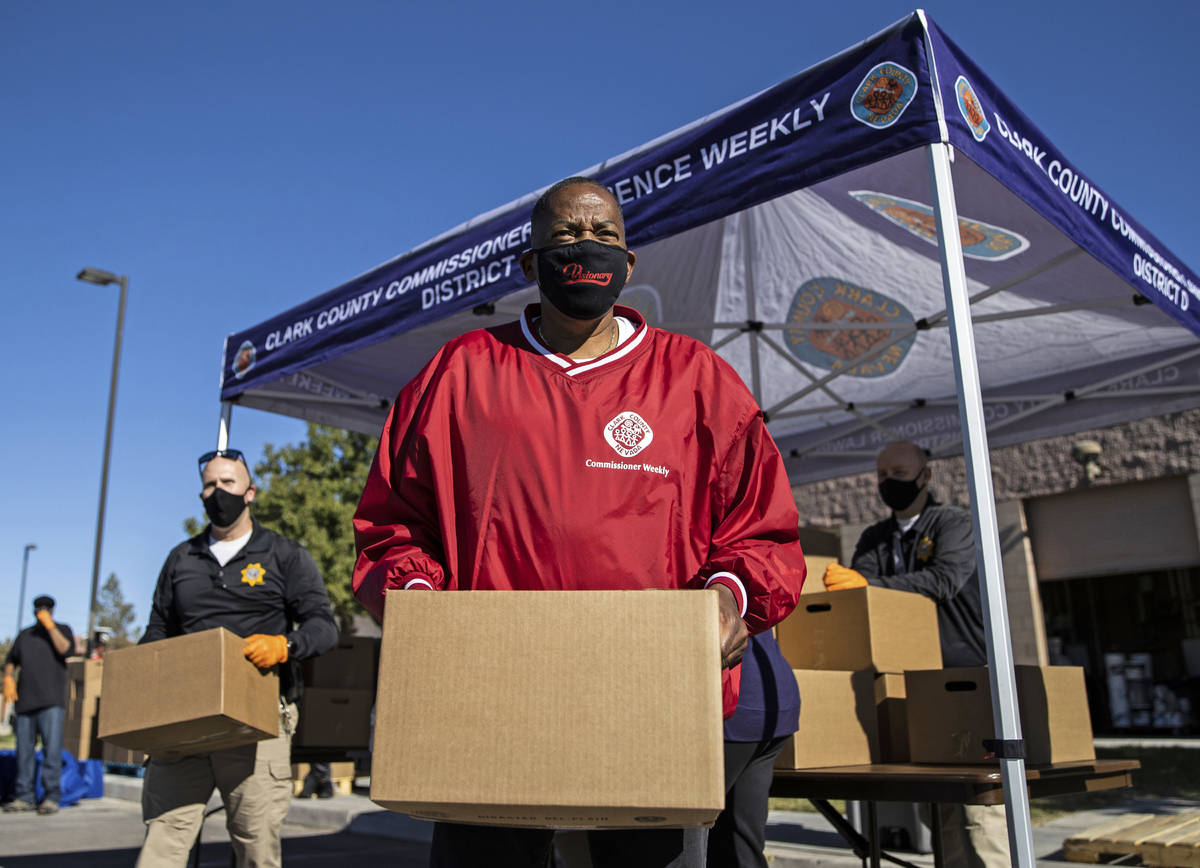 County Commission Vice Chairman Lawrence Weekly, middle, and Las Vegas Police officer Curt Atwo ...