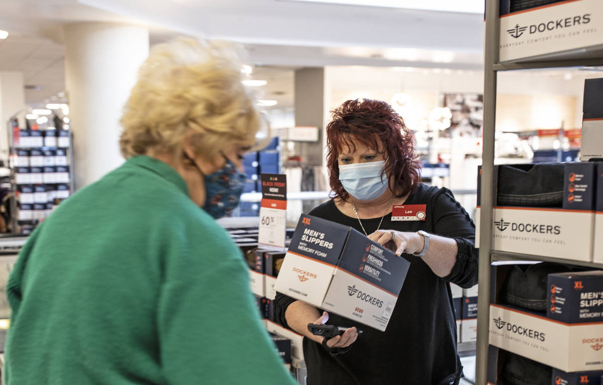 J. C. Penney general manager Lee Beamon, right, helps a shopper during Black Friday at the stor ...
