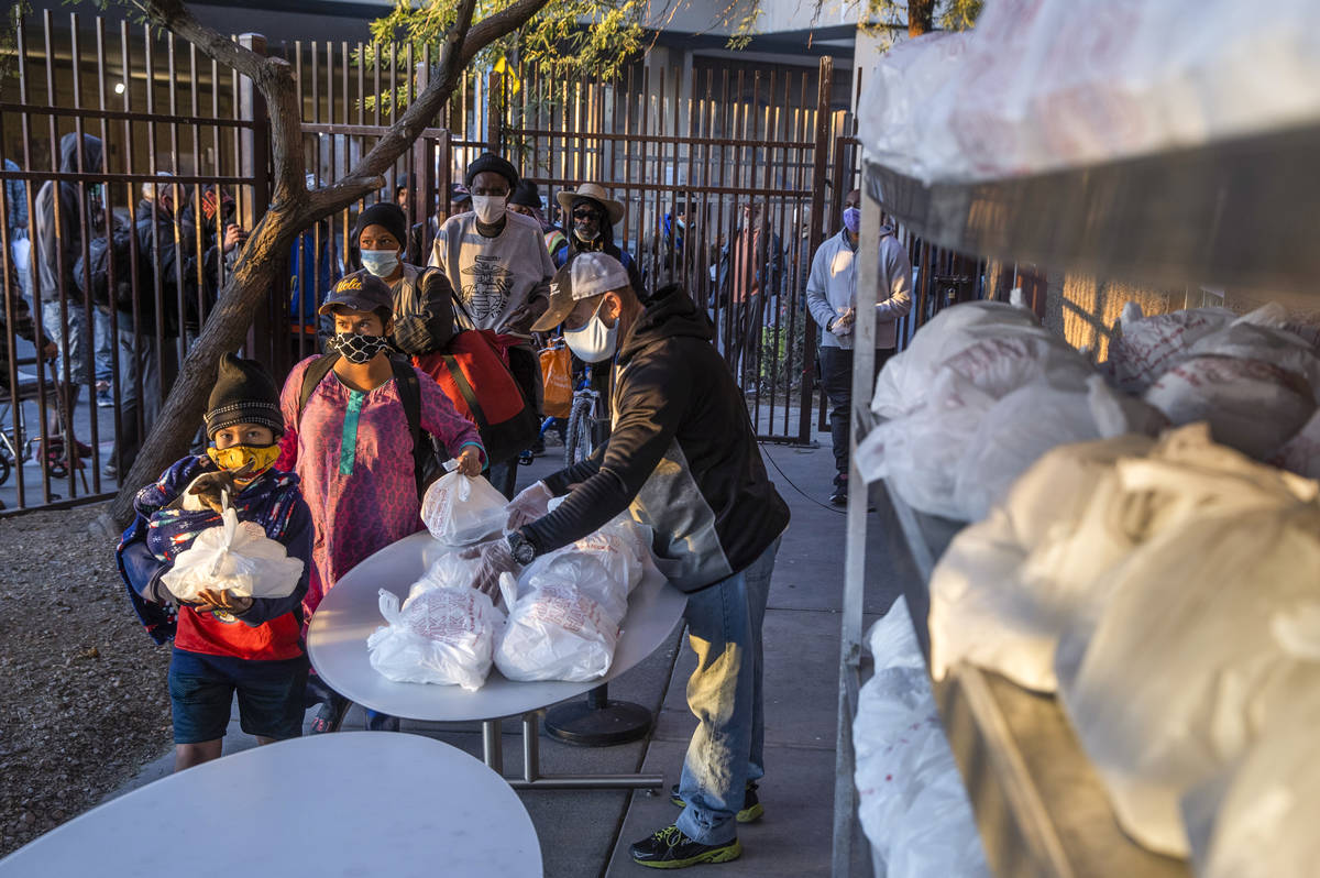 People in need receive prepared Thanksgiving meals at the Las Vegas Rescue Mission with food do ...