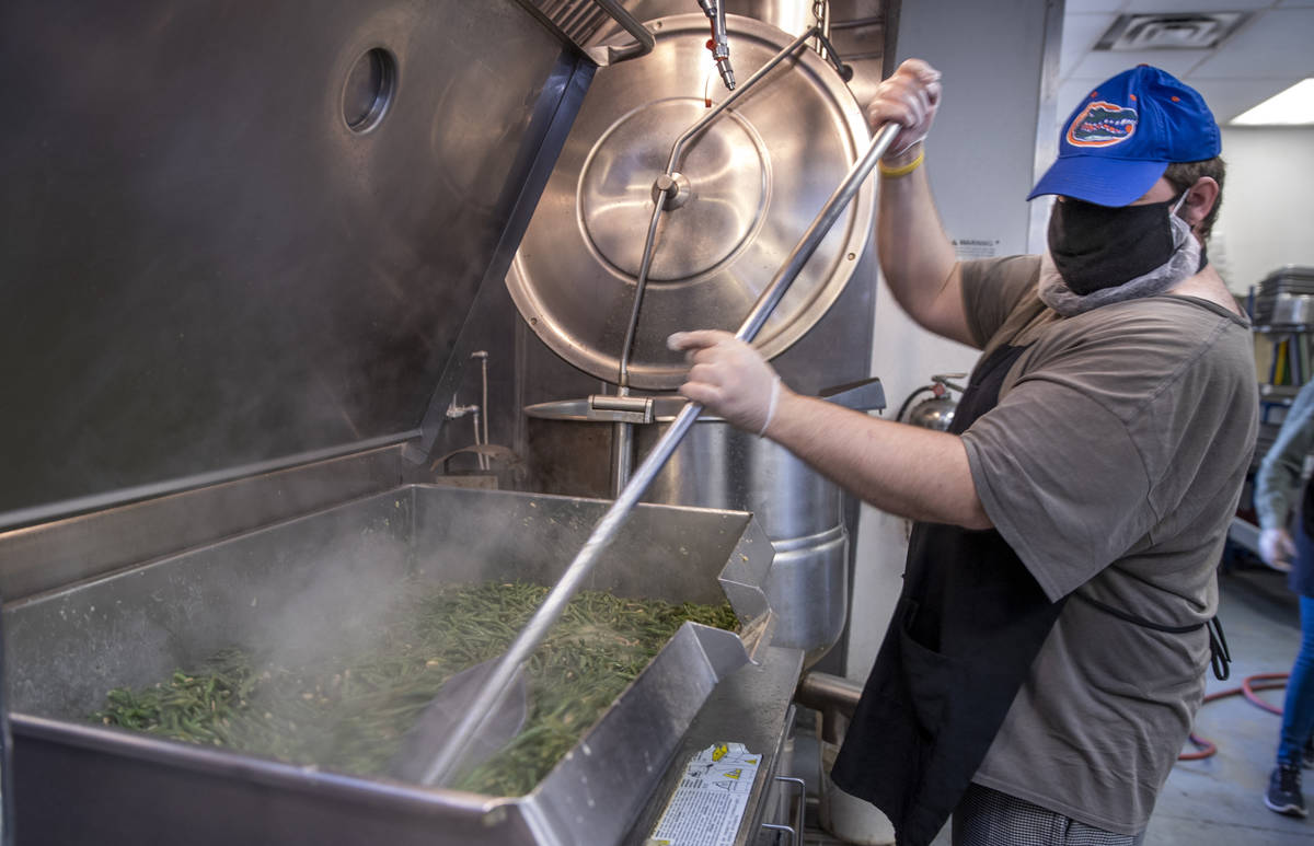 Dallin Brown cooks up green beans as part of a Thanksgiving meal at the Las Vegas Rescue Missio ...