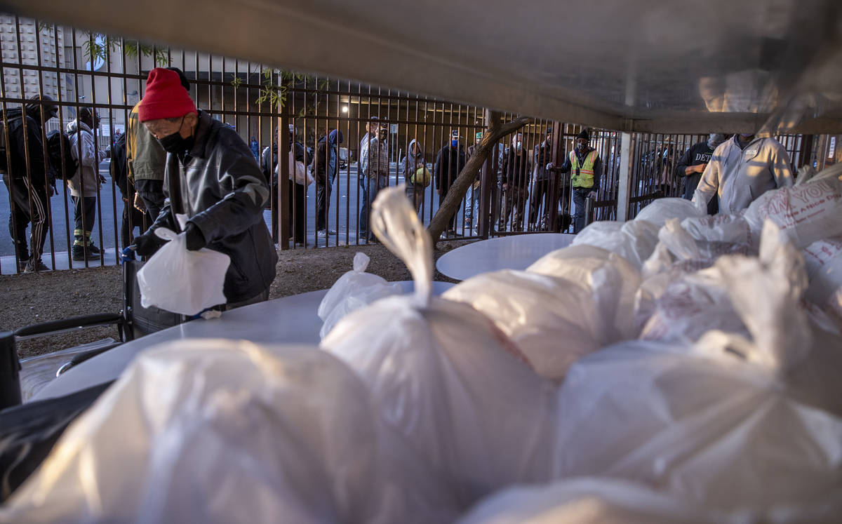 People in need receive prepared Thanksgiving meals at the Las Vegas Rescue Mission with food do ...