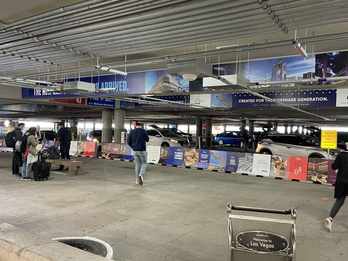 Travelers at McCarran International Airport wait for rides at the ride hailing pickup location ...