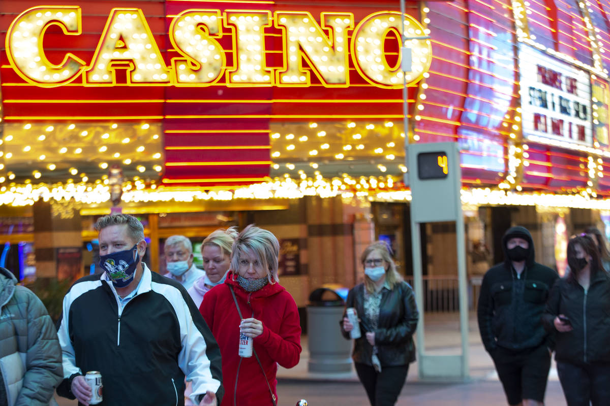 Visitors to Fremont Street Experience dress for cool temperatures on Thursday, Nov. 26, 2020, i ...
