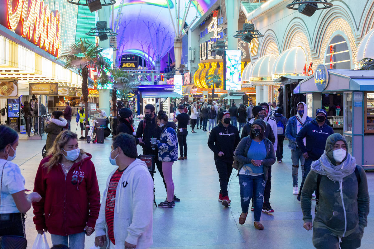 Visitors to Fremont Street Experience dress for cool temperatures on Thursday, Nov. 26, 2020, i ...