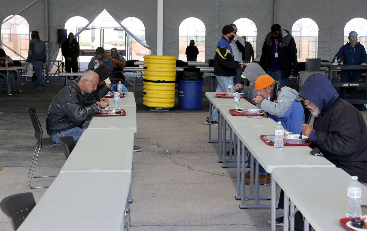 Clients eat a socially distanced Thanksgiving meal at the new outdoor dining pavilion at Cathol ...