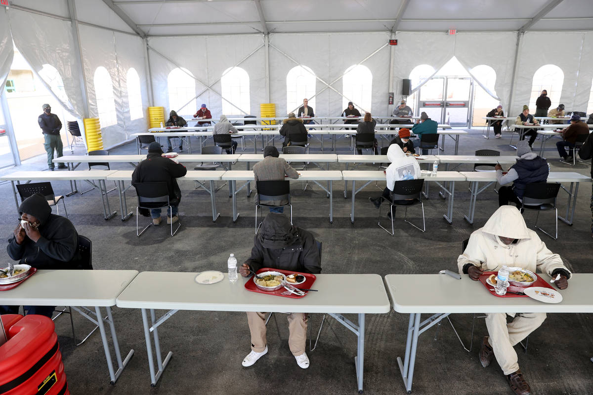 Clients eat a socially distanced Thanksgiving meal at the new outdoor dining pavilion at Cathol ...