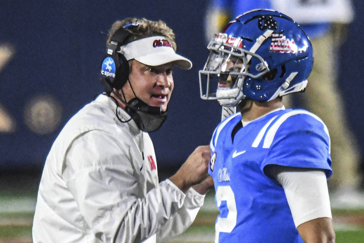 In this Nov. 14, 2020, file photo, Mississippi coach Lane Kiffin talks with quarterback Matt Co ...