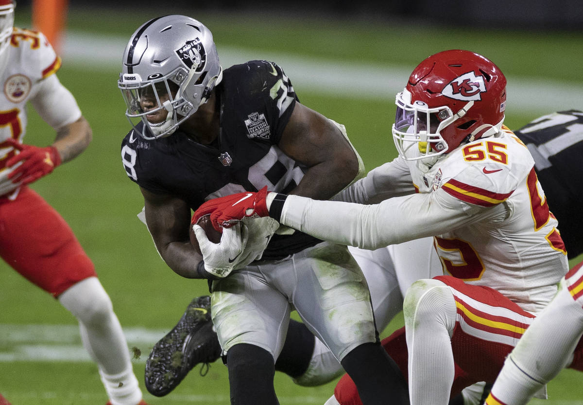 Las Vegas Raiders running back Josh Jacobs (28) fights for extra yardage against Kansas City Ch ...