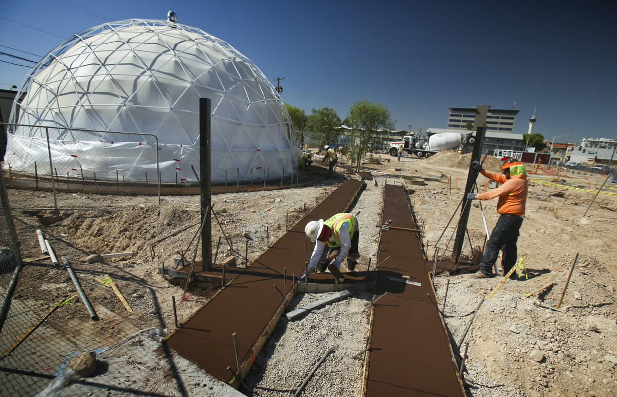 Men work on freshly poured concrete at Container Park, along Fremont Street and Seventh Street ...
