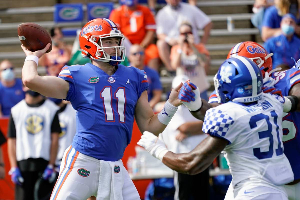 Florida quarterback Kyle Trask (11) throws a pass as Kentucky linebacker Jamar Watson (31) rush ...