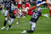 Kansas City Chiefs wide receiver Demarcus Robinson (11, center) is upended by Las Vegas Raiders ...