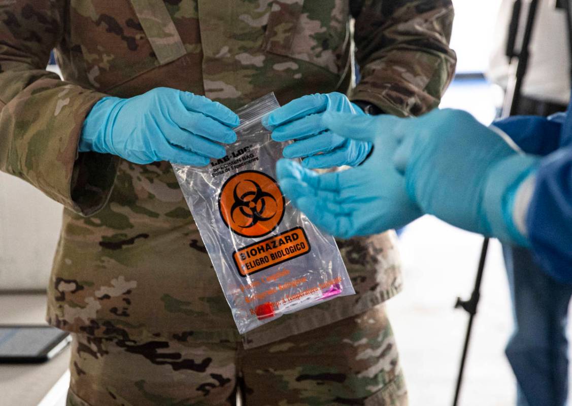 Nevada National Guard specialists Jonathan Macias, left, and Demetrie Barnett store a test tube ...