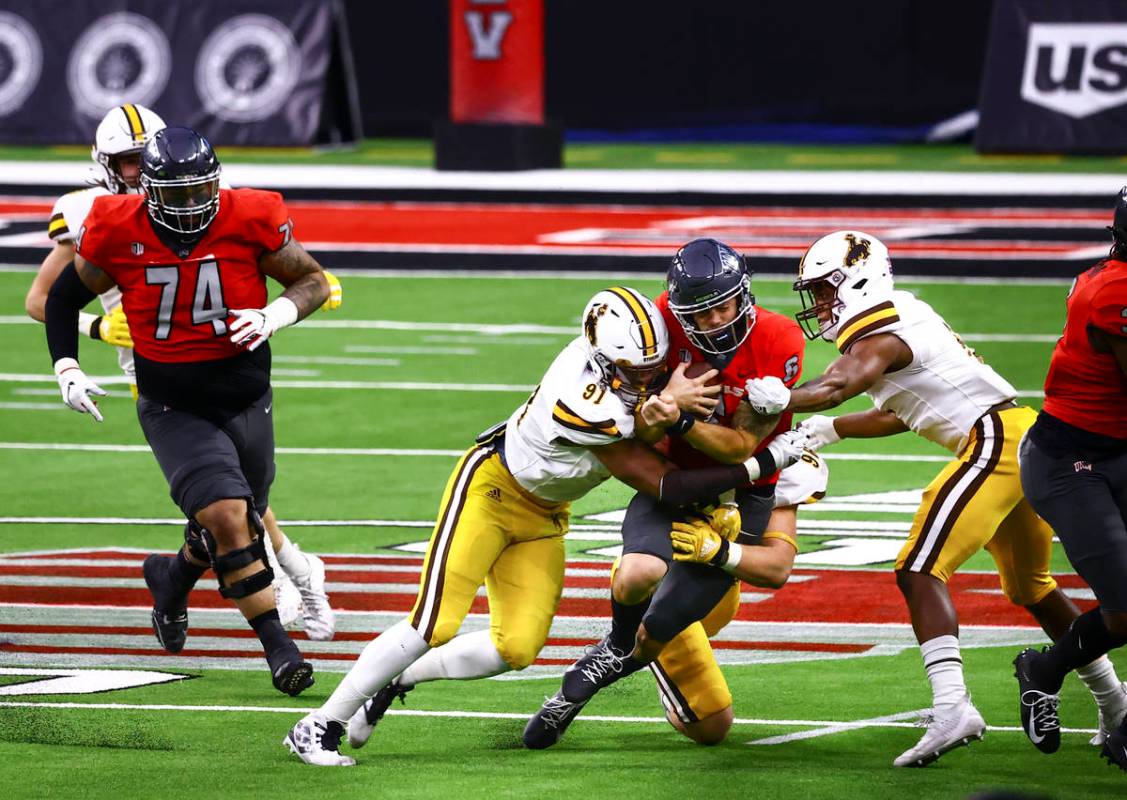 UNLV Rebels quarterback Max Gilliam (6) gets taken down by Wyoming Cowboys defensive end Jaylen ...