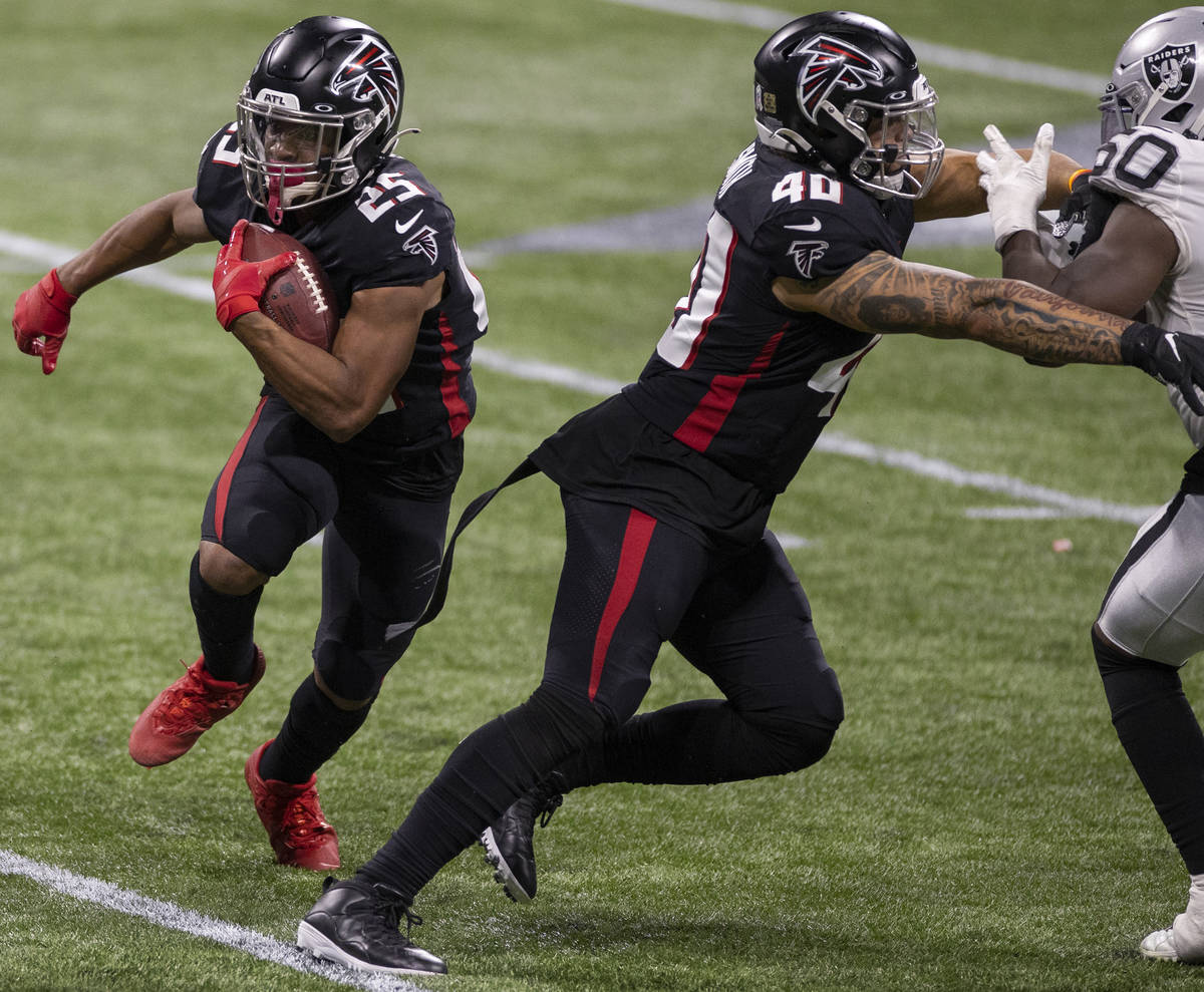 Atlanta Falcons running back Ito Smith (25) rushes up field past Las Vegas Raiders outside line ...