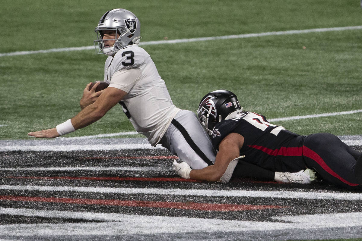 Las Vegas Raiders quarterback Nathan Peterman (3) is tackled by Atlanta Falcons defensive tackl ...