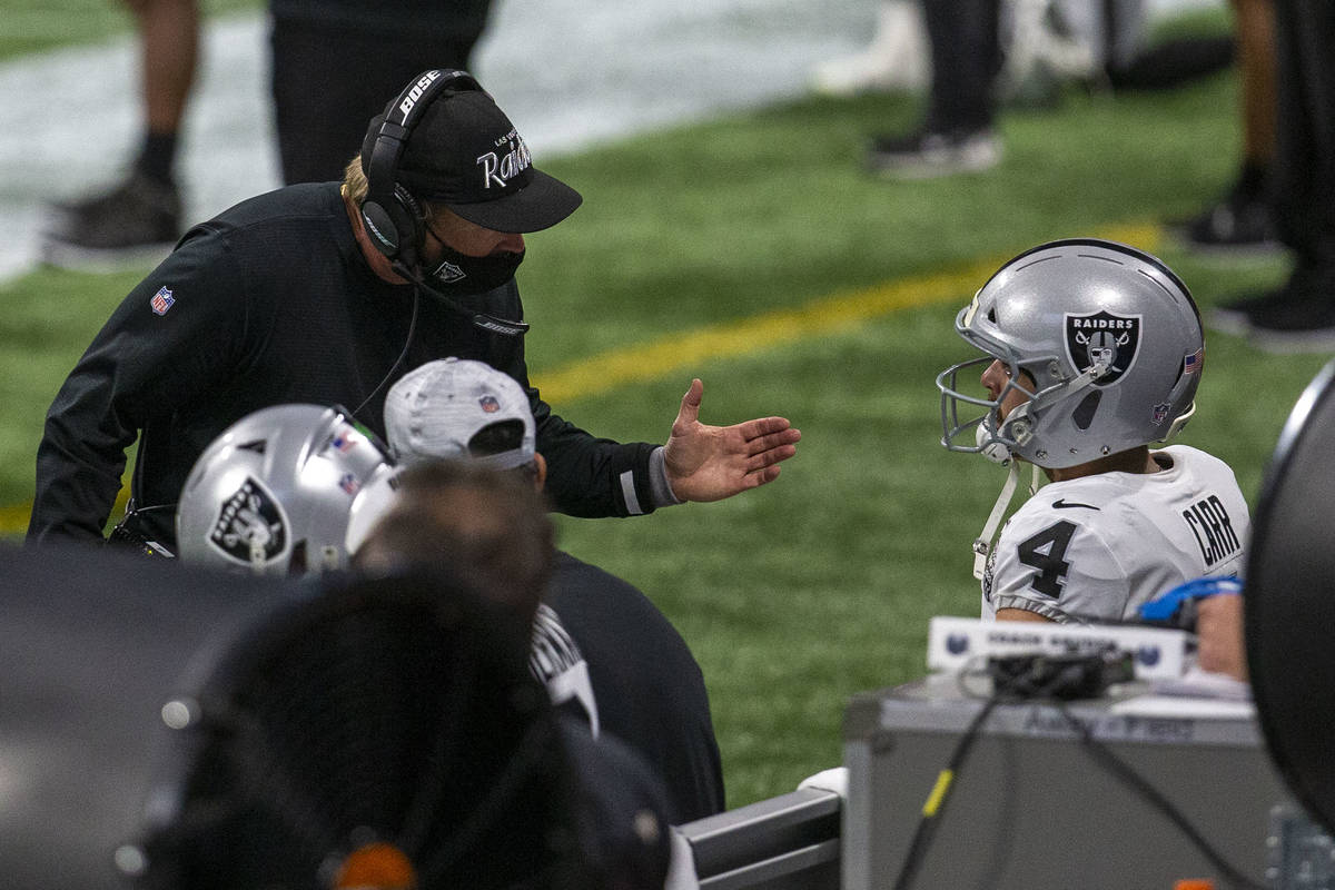 Las Vegas Raiders head coach Jon Gruden speaks to quarterback Derek Carr (4) on the sideline af ...