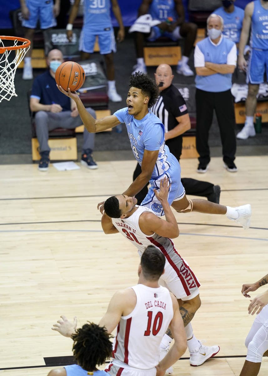 North Carolina guard Puff Johnson (14) leaps over UNLV guard Marvin Coleman (31) to shoot for t ...