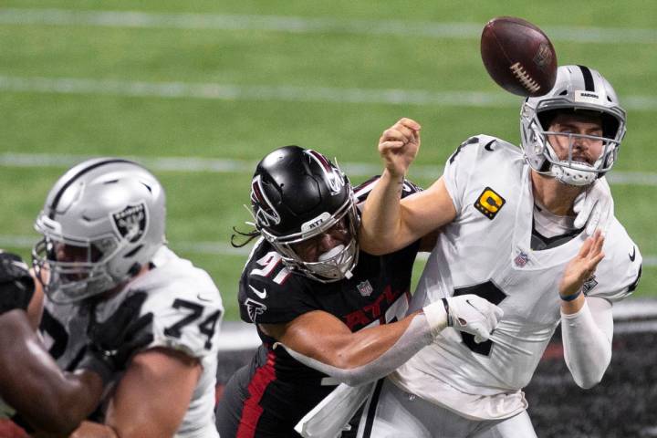 Las Vegas Raiders quarterback Derek Carr (4) is strip sacked by Atlanta Falcons defensive tackl ...