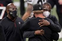Atlanta Falcons head coach Raheem Morris, right, hugs Las Vegas Raiders head coach Jon Gruden a ...