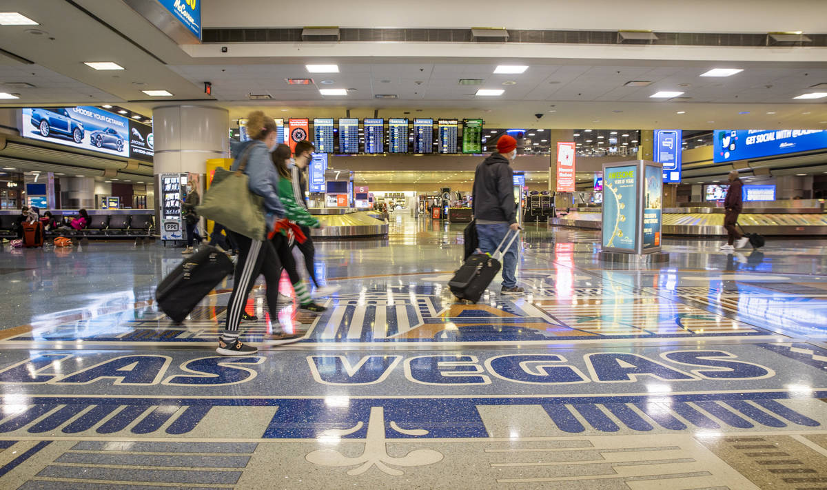 People come and go through baggage at Terminal 1 as holiday travel at McCarran International Ai ...