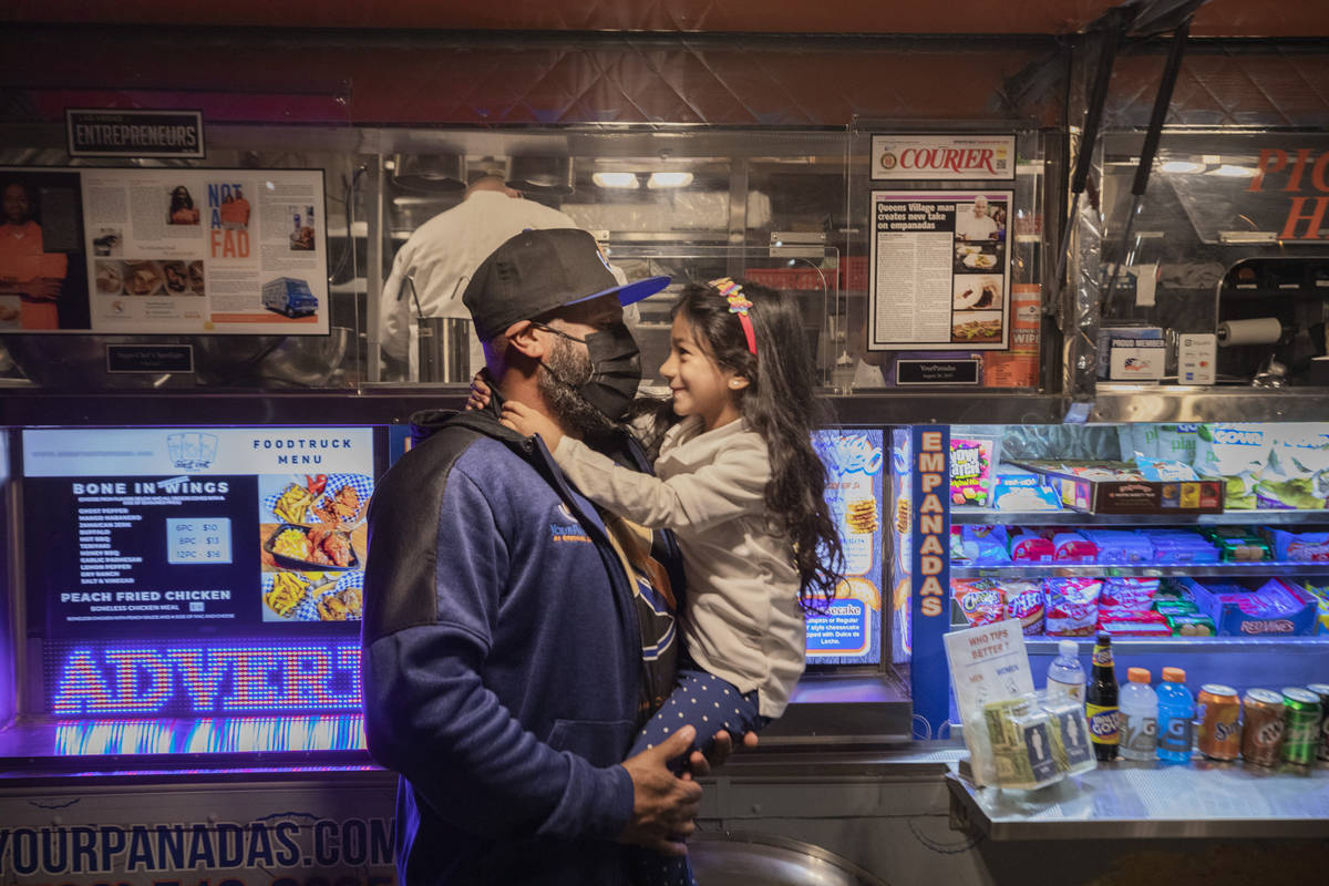 Owner Jonathan Batista and his daughter Laylani Batista, 4, hug next to his YourPanadas empanad ...