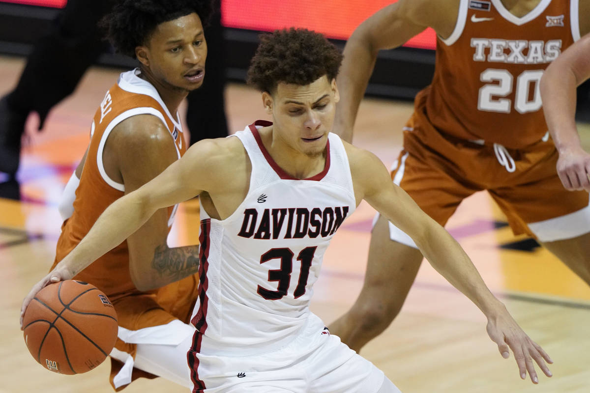 Davidson guard Kellan Grady (31) drives the ball away from Texas forwards Gerald Liddell (0) an ...