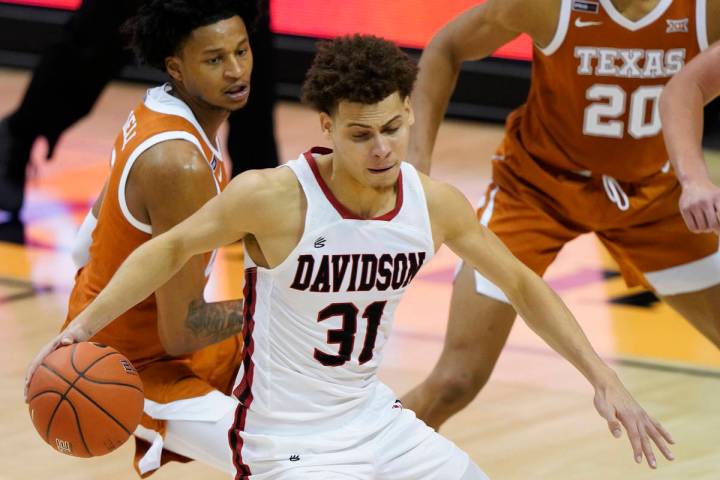 Davidson guard Kellan Grady (31) drives the ball away from Texas forwards Gerald Liddell (0) an ...