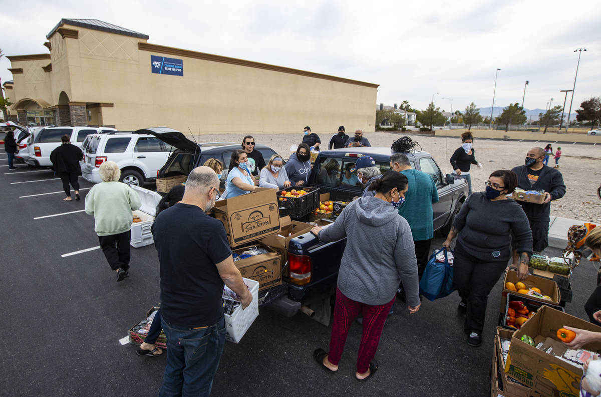 People in need get donated food from Amber Stevenson, upper right, wearing a bandana, at a shop ...