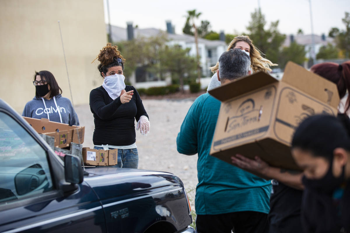 Amber Stevenson, left, gives out food to people in need at a shopping center in Las Vegas on We ...