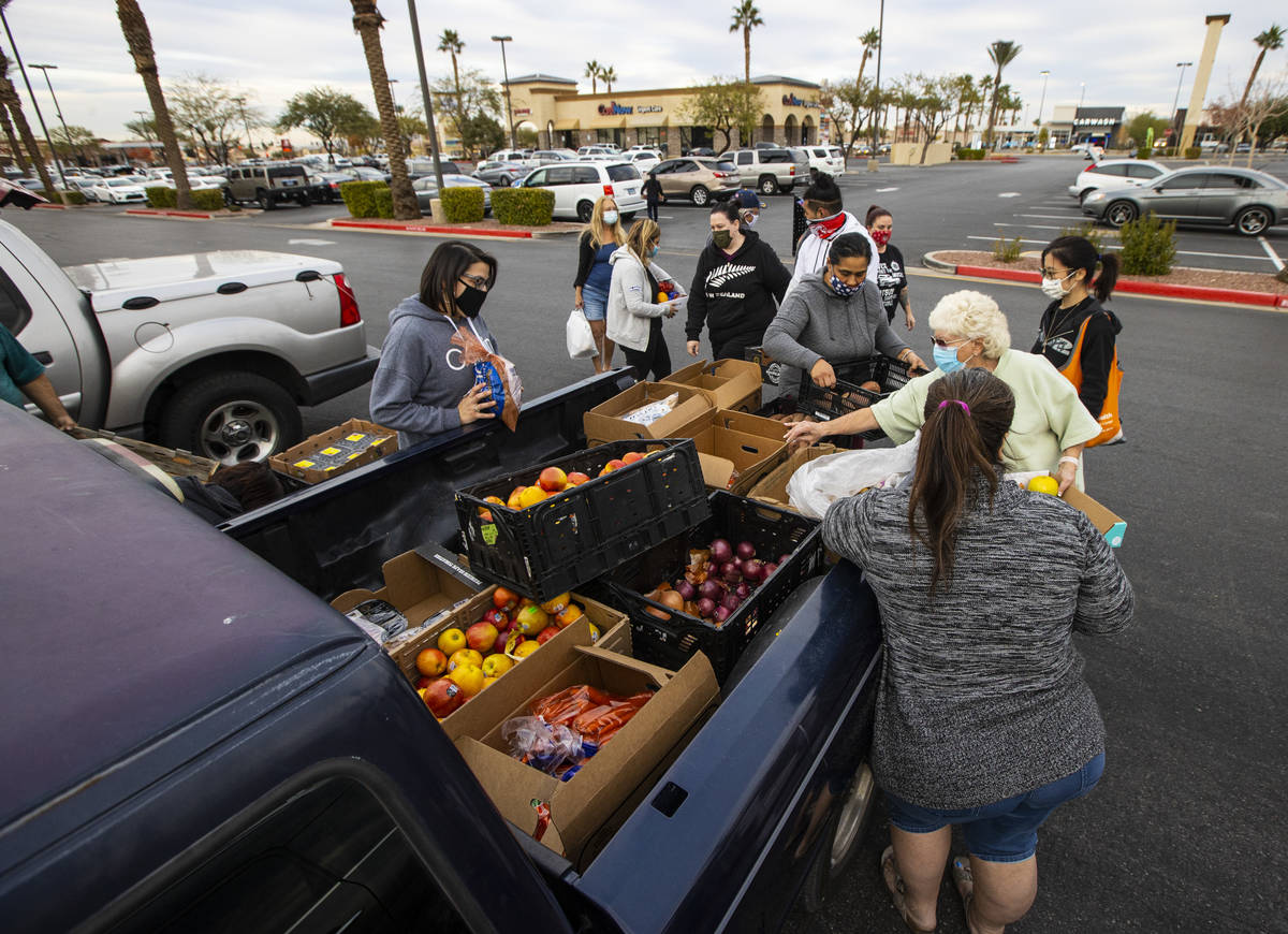 People in need get donated food from Amber Stevenson, not pictured, at a shopping center in Las ...
