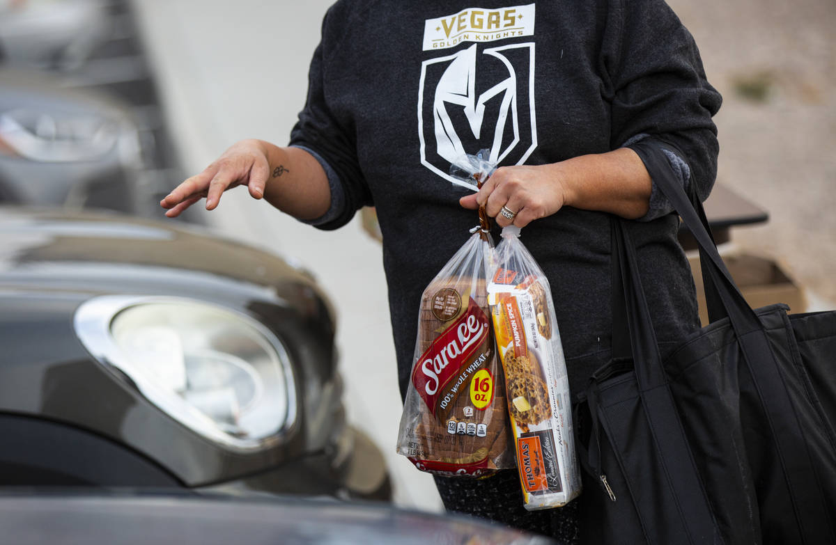 A woman gathers donated food from Amber Stevenson at a shopping center in Las Vegas on Wednesda ...