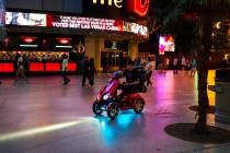 A man rides a scooter along the Fremont Street Experience as hotel-casinos reopen in downtown L ...
