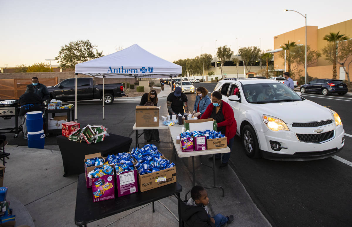 Kisha Walker, a volunteer with Liberty Baptist Church, center, prepares food and snacks to hand ...