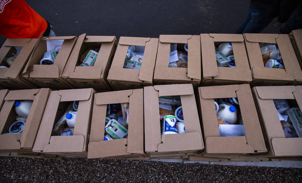 Volunteers with Home Depot prepare to deliver boxes with meals, holiday decorating kits, hand s ...